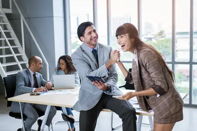 stock-photo-of-man-and-woman-laughing-in-office-setting